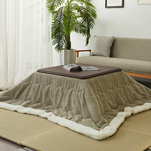 Modern kotatsu table with blanket and book in living room